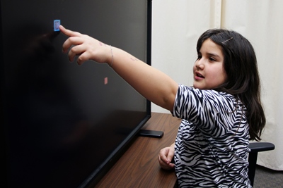 girl pointing at image on monitor
