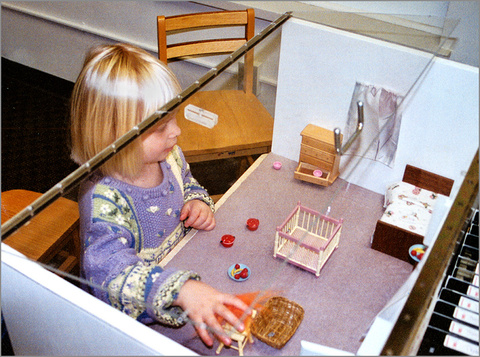 Child moving objects in dollhouse