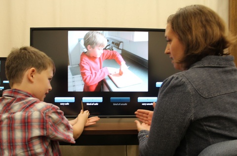 Adult and child at computer monitor